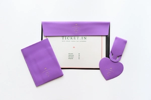 Detail view of purple faux leather travel set including luggage tag and ticket organizer