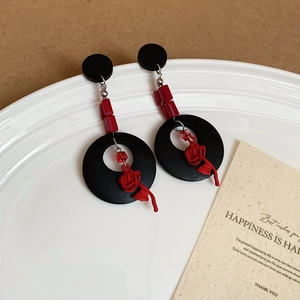 Gros plan de boucles d'oreilles vintage avec pendentifs roses 3D sur plateau blanc