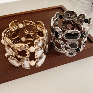 Close-up of vintage geometric elastic bracelets with hammer textured metal and resin inlay