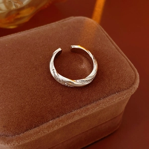 Detailed macro of silver twisted ring with zircon accents on brown velvet box