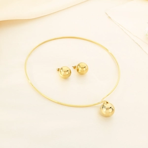 Detail of gold titanium steel jewelry set with spherical pendant necklace and ball studs