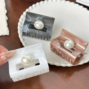 Three vintage marble resin hair claws with pearl details in grey, brown, and white