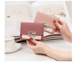 Hand holding compact PU leather accordion wallets in pink shades with metal square buckles