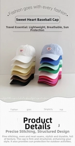 Close-up of stacked cotton baseball caps featuring embroidered heart logos in multi-colors