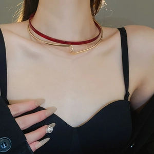Detail of double-layer resin choker with red ring and wavy gold geometric metal band