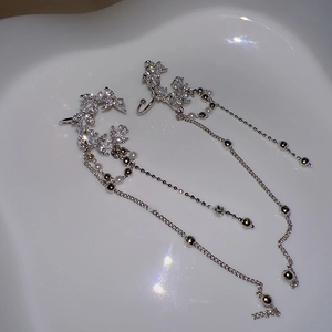 Detail of silver long tassel earrings with white zircon leaves and faux pearls
