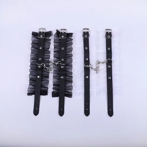 Detailed view of Gothic lace-trimmed leather cuffs with silver rivets and metal chains