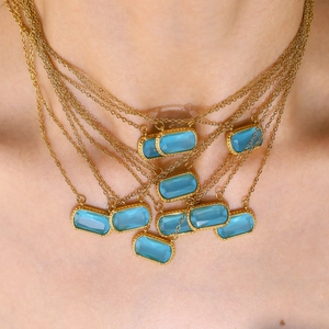 Layered gold necklace featuring a vibrant sky blue rectangular crystal pendant for women