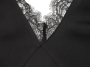 Close-up of elegant V-neck design with delicate black lace trim on smooth fabric