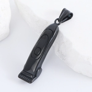 Close-up of black stainless steel barber razor pendant on white stone surface
