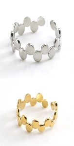 Close-up of geometric wave rings in gold and silver finish with adjustable open bands