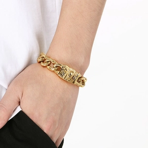 Detail of vintage gold-tone Cuban chain bracelet featuring intricate floral engravings