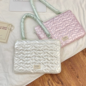 Detailed view of heart-quilted laptop sleeve with satin finish and mint green handle