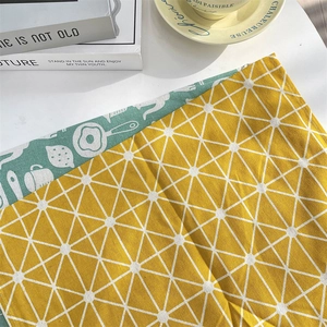 Gros plan du set de table réversible avec grille jaune et motifs de cuisine vert pastel