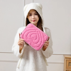 Detailed view of pink heart quilted tablet sleeve with white trim and dual metal zippers