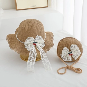 Detail of straw hat and bag set with lace bows and cherry accents for girls