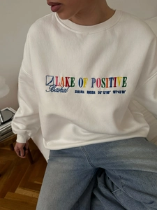 White crewneck sweatshirt with colorful letter embroidery and a loose fit for women