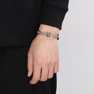 Close-up of a silver thorn knot bracelet in punk style on a model's wrist