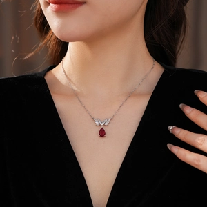 Close-up of zircon flower necklace with a pear-cut red gemstone on a model wearing black