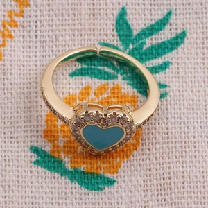 Dettaglio dell'anello a cuore placcato oro con smalto verde acqua e zirconi bianchi