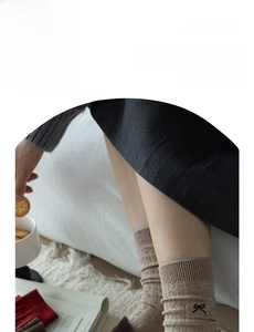 Detail of oatmeal knit crew socks with cute embroidered bow and colorful speckled yarn texture