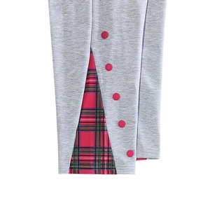 Détail du pantalon gris avec fente latérale en tissu écossais et boutons rouges