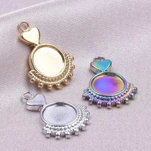 Three metal heart pendant bases in gold, silver and rainbow finish on grey silk fabric