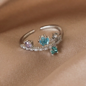 Macro shot of silver adjustable branch ring with purple, blue, and emerald gemstones