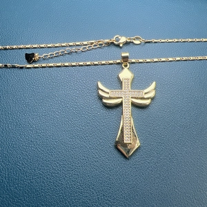 Golden cross necklace with angel wings and micro-pave cubic zirconia on blue leather