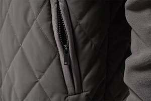 Close-up of diamond-quilted jacket fabric with zipper pocket and fleece sleeve detail