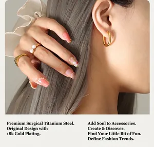 Close-up of 18k gold plated titanium steel U-shaped earrings and pearl rings on model