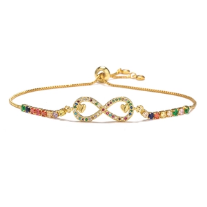 Macro detail of 18K gold infinity bracelet featuring colorful zircons and hearts