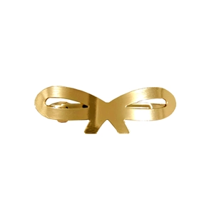 Detailed close-up of a glossy gold metal bow hair clip with a smooth polished finish