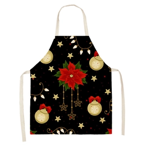 Detail of linen Christmas apron with poinsettia, golden stars and lights on black background