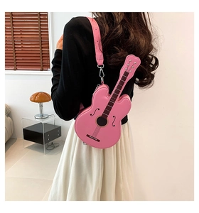 Pink guitar-shaped PU leather crossbody bag worn by a model in a bright indoor setting