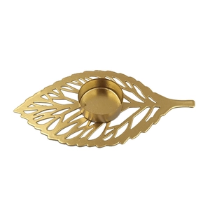 Golden leaf iron candle holder with hollow vein pattern on a clean white background