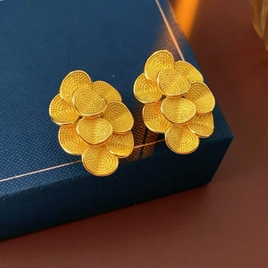 Gros plan sur les boucles d'oreilles fleur plaquées or 18 carats texturées