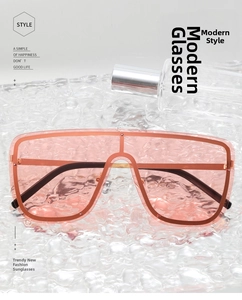 Detail of pink oversized rimless sunglasses with gold frame on a water ripple glass base