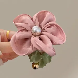 Pink silk floral hair scrunchie with center pearl, green leaf and gold bell accent