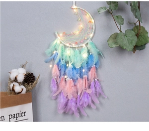 Detail of moon dreamcatcher with colorful feathers, beads and warm glowing LED lights
