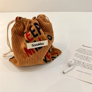 Macro view of corduroy drawstring pouch showing soft ribbed texture and printed details