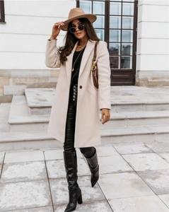 Outdoor shot of a long beige wool coat with lapel collar and buttons in a street setting