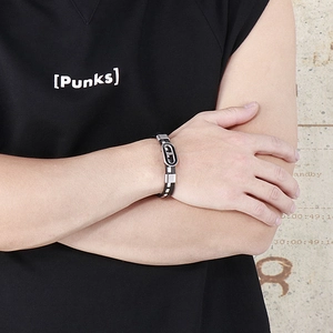 Gros plan d'un bracelet en cuir tressé pour homme avec une boucle ovale en acier argenté