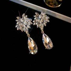 Macro de boucles d'oreilles goutte d'eau en argent avec cristaux sur velours noir