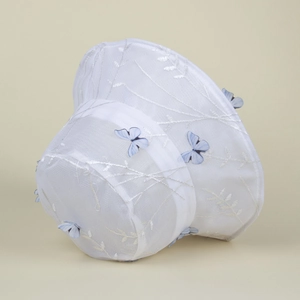 Détail du chapeau bob en maille blanche avec broderie et papillons 3D bleus
