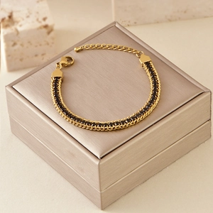 Close-up of golden titanium steel double-layer chain bracelet with black zircon inlay