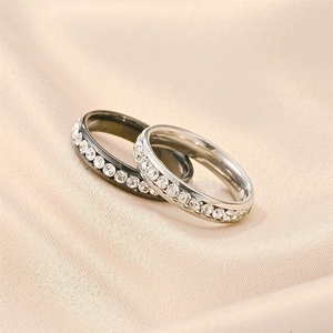 Close-up of black and silver titanium rings with zircon inlay on champagne silk