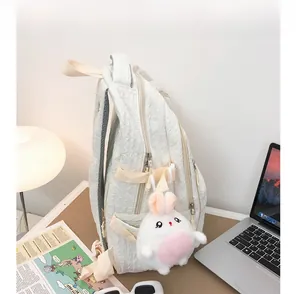 Détail d'un sac à dos matelassé beige avec breloque lapin mignon sur un bureau d'étude