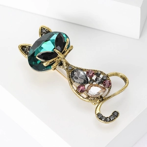 Close-up of cat brooch with emerald green crystal head and vintage gold finish