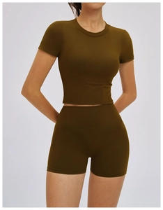 Detail of ribbed olive green short sleeve yoga top and high waist fitness shorts